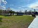 Community park with lush green grass, playground, and lakeside picnic area under a bright sky at 281 San Gabriel St, Winter Springs, FL 32708