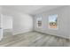 Well-lit bedroom with light wood-look flooring and views of the property from two windows at 325 Marion Oaks Trail, Ocala, FL 34473