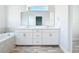 Elegant bathroom features double vanity with stone countertop, modern fixtures, and decorative tile surround on soaking tub at 333 Bahia Cir, Longwood, FL 32750