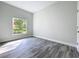 Sunlit bedroom showcasing wood-look tile floors and a large window with a lush green view at 333 Bahia Cir, Longwood, FL 32750
