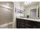 Bathroom featuring a shower, double sinks, granite countertops, dark wood cabinets, and nautcal decor at 4157 Lana Ave, Davenport, FL 33897
