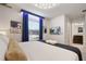 Bright bedroom with an ensuite bathroom, large window, TV, blue curtains, and plush bedding at 4157 Lana Ave, Davenport, FL 33897