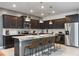 Modern kitchen featuring dark cabinetry, granite countertops, stainless steel appliances, and a kitchen island at 4157 Lana Ave, Davenport, FL 33897