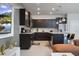 Modern kitchen with dark cabinets, granite countertops, stainless steel appliances, and island seating at 4157 Lana Ave, Davenport, FL 33897