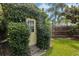 A charming garden door covered in greenery, offering a secluded entrance to the backyard at 421 E Gore St, Orlando, FL 32806