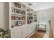 Bright hallway featuring built-in bookshelves and cabinets and a tufted chair at 421 E Gore St, Orlando, FL 32806
