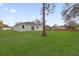 Large backyard with lush green grass, privacy fence, and a view of the home's rear facade at 4944 Tinkham Ave, Orlando, FL 32812