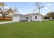 A well-manicured lawn highlights this single-story home with an attached garage and inviting curb appeal at 4944 Tinkham Ave, Orlando, FL 32812