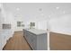 Bright kitchen featuring a large island, quartz countertops, and modern cabinets at 4944 Tinkham Ave, Orlando, FL 32812