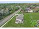 Aerial view of a home with green lawn in a neighborhood of mature trees and a road at 495 Dean Creek Ln, Orlando, FL 32825