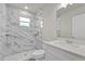 A remodeled bathroom with white marble shower, new tile, and white vanity at 495 Dean Creek Ln, Orlando, FL 32825