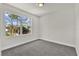 A minimalist bedroom with a large window and neutral gray carpet at 495 Dean Creek Ln, Orlando, FL 32825
