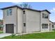 Modern two-story home showcasing a dark-colored attached garage and a simple lawn at 495 Dean Creek Ln, Orlando, FL 32825
