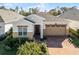 Attractive one-story home featuring a brick driveway, a two-car garage, and lush landscaping at 5159 Twin Lakes Blvd, St Cloud, FL 34772