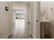 Hallway showcasing tile flooring, a pedestal sink powder room, and sliding glass doors leading to the backyard at 5333 Dragonfly Dr, Wildwood, FL 34785