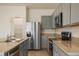 A well-lit kitchen showcasing stainless steel appliances, granite countertops, and light grey cabinets at 5333 Dragonfly Dr, Wildwood, FL 34785