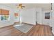 Living room with wood floors, bright windows, ceiling fan, and an area rug at 591 Juniper Springs Dr, Groveland, FL 34736