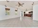 Spacious living room featuring tile floors, ceiling fan, and access to the kitchen at 591 Juniper Springs Dr, Groveland, FL 34736