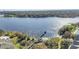 Scenic aerial view featuring a lake, a wooden pier, and lush green foliage at 6593 Queens Borough Ave # 202, Orlando, FL 32835
