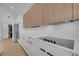 Modern kitchen features sleek white cabinets and a contemporary cooktop with stainless steel appliances at 6593 Queens Borough Ave # 202, Orlando, FL 32835