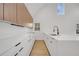 Modern kitchen featuring sleek white cabinets, stainless steel sink, black hardware, and wood floors for added warmth at 6593 Queens Borough Ave # 202, Orlando, FL 32835