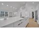 Contemporary kitchen with an open concept showcasing white waterfall island with bar seating and modern black hardware at 6593 Queens Borough Ave # 202, Orlando, FL 32835