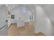 Modern kitchen with white cabinets, waterfall island, stainless appliances, wood floors, and a vaulted ceiling with windows at 6593 Queens Borough Ave # 202, Orlando, FL 32835