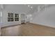 Bright living room features wood floors, large windows, and staircase at 6593 Queens Borough Ave # 202, Orlando, FL 32835