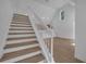 Staircase with white rails and wood steps provides access to the spacious living area at 6593 Queens Borough Ave # 202, Orlando, FL 32835