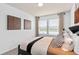 Neutral bedroom featuring large window, art, and a patterned duvet at 6736 Reverie Park Ave, Orlando, FL 32829