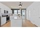 Bright kitchen features white cabinets, stainless steel appliances, a center island, and modern pendant lighting at 6736 Reverie Park Ave, Orlando, FL 32829