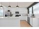 Well-equipped kitchen with stainless steel appliances, white cabinets, quartz countertops and modern lighting at 6736 Reverie Park Ave, Orlando, FL 32829