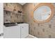 Stylish laundry room with wallpaper, shelving, washer, dryer, and a round decorative mirror at 6736 Reverie Park Ave, Orlando, FL 32829