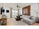 Bright living room with a large modular sofa, stylish wood accent wall and modern decor at 6736 Reverie Park Ave, Orlando, FL 32829