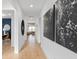 Hallway with decorative art leading into an office and living area featuring hardwood floors at 6744 Willow View Ave, Orlando, FL 32829