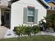 Landscaped front yard featuring green plants, a window with green shutters, and white rock groundcover at 7035 Oxbow Rd, Minneola, FL 34715