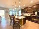Modern kitchen features dark cabinets, stainless steel appliances and a center island with barstool seating at 7035 Oxbow Rd, Minneola, FL 34715