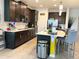 Modern kitchen with dark cabinets, stainless steel appliances, and a white countertop island with barstool seating at 7035 Oxbow Rd, Minneola, FL 34715