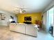 Open living room with a large couch, modern decor, and a sliding glass door for natural light at 7035 Oxbow Rd, Minneola, FL 34715