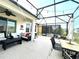 Enclosed patio featuring an outdoor dining area, comfortable seating, and a ceiling fan, perfect for relaxing at 7035 Oxbow Rd, Minneola, FL 34715