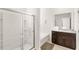 Bright bathroom featuring a shower with glass door and dark vanity with granite countertop at 7845 Oak Reflection Loop, Davenport, FL 33837