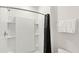 Bright bathroom showing a clean white shower with a black curtain and handy built in shelves at 7845 Oak Reflection Loop, Davenport, FL 33837
