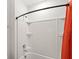 Bright bathroom features a curved shower rod with an orange shower curtain at 7845 Oak Reflection Loop, Davenport, FL 33837