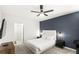 Modern bedroom showcasing a bed with a padded headboard and a striking blue accent wall at 7845 Oak Reflection Loop, Davenport, FL 33837