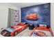 Themed bedroom with race car beds and a custom 'Cars' themed mural on the wall at 7845 Oak Reflection Loop, Davenport, FL 33837