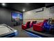 Modern entertainment room with a large screen, red reclining chairs, and blue accent lights at 7845 Oak Reflection Loop, Davenport, FL 33837