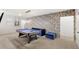 Spacious game room with a pool table, blue sofa, and cartoon-themed wallpaper at 7845 Oak Reflection Loop, Davenport, FL 33837