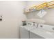 Practical laundry area with a modern washer and dryer and handy shelves for storage at 7845 Oak Reflection Loop, Davenport, FL 33837