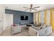Elegant living room features a decorative accent wall, comfortable seating, and large windows for ample natural light at 7845 Oak Reflection Loop, Davenport, FL 33837