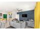 Stylish living room featuring tufted sofas, a modern accent wall, and yellow curtains, offering a luxurious and inviting space at 7845 Oak Reflection Loop, Davenport, FL 33837